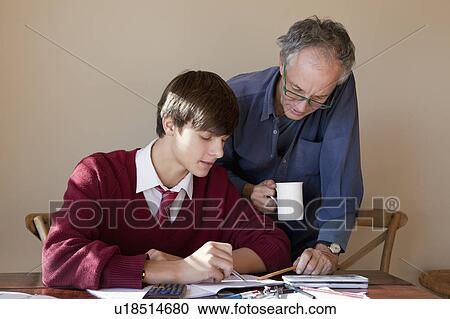 Stock Image - Father helping son with homework. Fotosearch