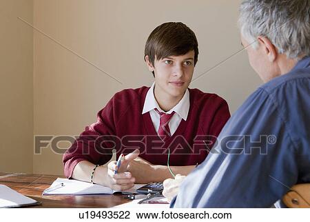 Stock Image - Father helping son with homework. Fotosearch