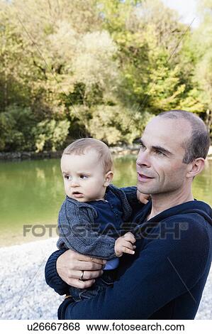 Father holding baby by creek View Large Photo Image Stock Photo - Father holding baby by creek. Fotosearch