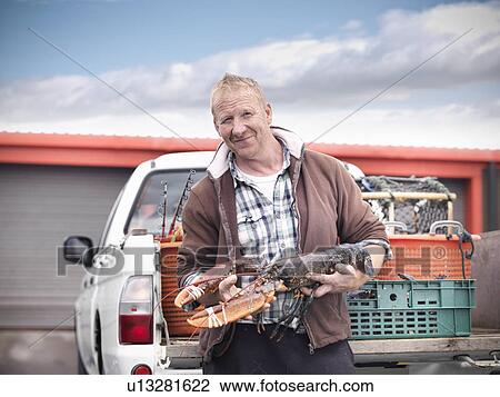Fisherman holding lobster by truck View Large Photo Image Stock Image - Fisherman holding lobster by truck. Fotosearch