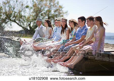 Stock Photo - Friends kicking water from deck. Fotosearch