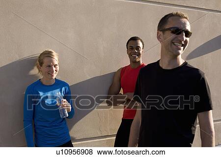 Stock Photo - Friends talking after running together. Fotosearch