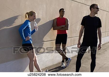 Stock Photo - Friends talking after running together. Fotosearch