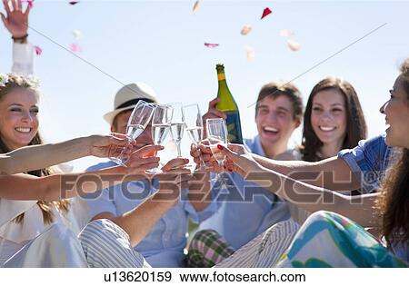 Friends toasting newlywed couple View Large Photo Image Stock Photo - Friends toasting newlywed couple. Fotosearch