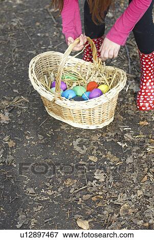 Girl carrying basket of Easter eggs View Large Photo Image Stock Photo - Girl carrying basket of Easter eggs. Fotosearch