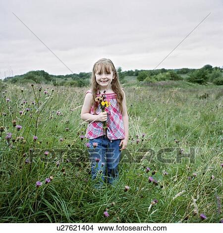 Girl carrying flowers in field View Large Photo Image Picture - Girl carrying flowers in field. Fotosearch