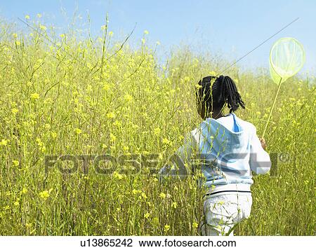 Girl carrying net in field of flowers View Large Photo Image Stock Image - Girl carrying net in field of flowers. Fotosearch