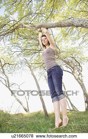 Stock Photo - Girl climbing tree outdoors. Fotosearch
