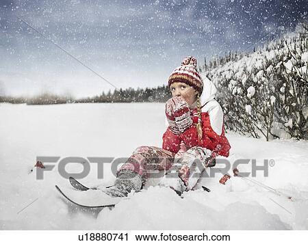 Stock Image - Girl eating snow outdoors. Fotosearch
