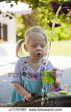 Girl getting water from outdoor fountain View Large Photo Image Stock Photo - Girl getting water from outdoor fountain. Fotosearch