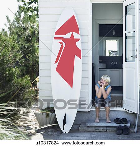 Picture - Girl in back doorway with surfboard. Fotosearch