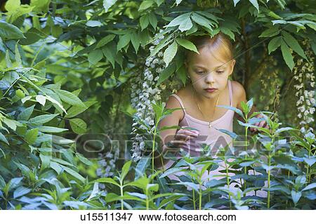 Stock Photo - Girl in ballet costume playing in bush. Fotosearch