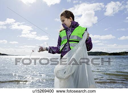 Girl in safety vest cleaning beach View Large Photo Image Stock Image - Girl in safety vest cleaning beach. Fotosearch