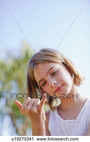 Girl inspecting dragonfly on her finger View Large Photo Image Stock Image - Girl inspecting dragonfly on her finger. Fotosearch