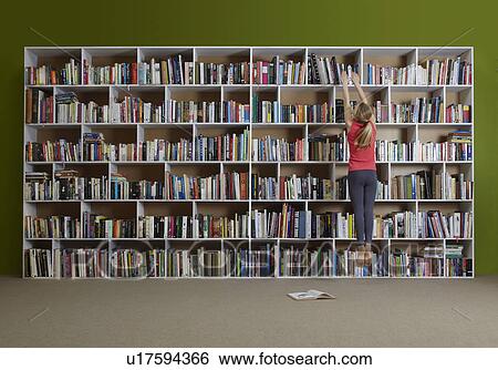 Girl jumping for book on high shelf View Large Photo Image Stock Photograph - Girl jumping for book on high shelf. Fotosearch