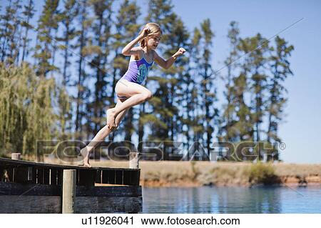 Girl jumping into lake from jetty View Large Photo Image Stock Image - Girl jumping into lake from jetty. Fotosearch
