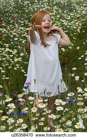 Stock Image - Girl laughing in field of flowers. Fotosearch