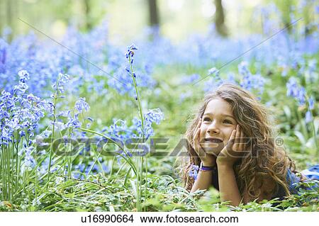 Picture - Girl laying in field of flowers. Fotosearch
