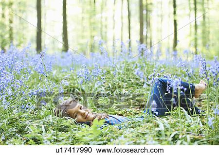 Stock Image - Girl laying in field of flowers. Fotosearch