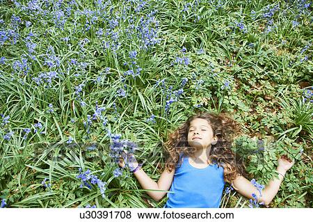 Stock Photo - Girl laying in field of flowers. Fotosearch