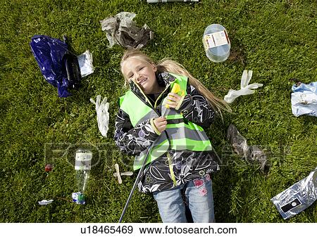 Girl laying in garbage on lawn View Large Photo Image Stock Photo - Girl laying in garbage on lawn. Fotosearch