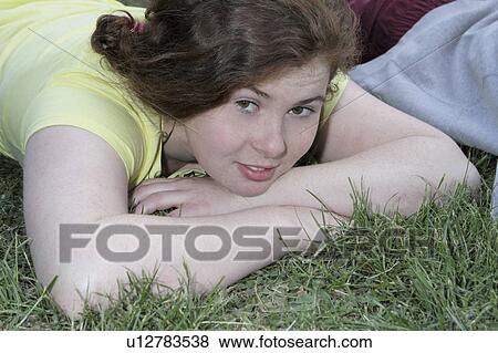 Girl laying in grass at park View Large Photo Image Stock Photo - Girl laying in grass at park. Fotosearch