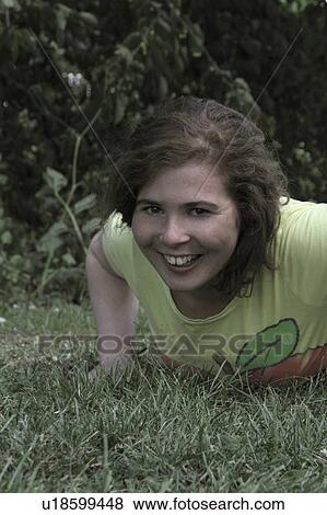 Stock Photo - Girl laying in grass at park. Fotosearch
