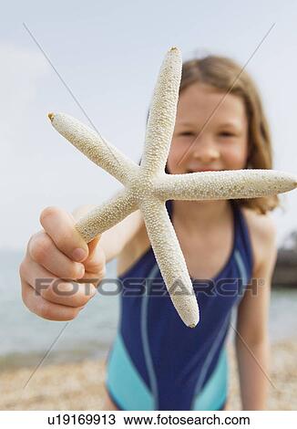 Girl offering starfish on beach View Large Photo Image Stock Image - Girl offering starfish on beach. Fotosearch