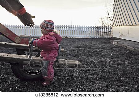 Girl playing on seesaw at playground View Large Photo Image Stock Image - Girl playing on seesaw at playground. Fotosearch