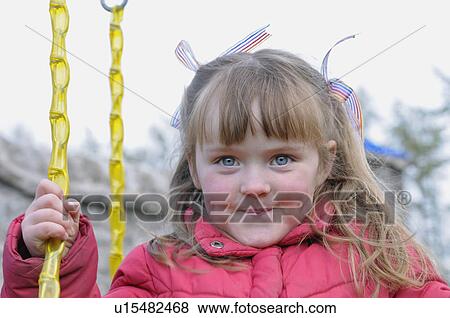 Stock Photo - Girl playing on swing outdoors. Fotosearch