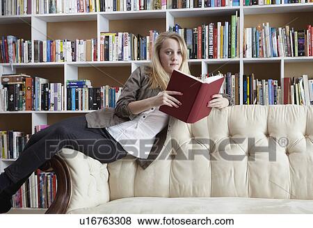 Girl reading on couch in library View Large Photo Image Stock Photo - Girl reading on couch in library. Fotosearch