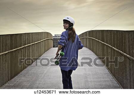 Girl riding skateboard on walkway View Large Photo Image Stock Image - Girl riding skateboard on walkway. Fotosearch