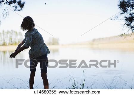 Girl skipping stones in lake View Large Photo Image Stock Photography - Girl skipping stones in lake. Fotosearch