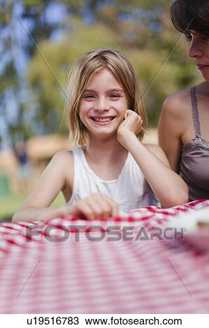 Girl smiling at picnic table View Large Photo Image Stock Image - Girl smiling at picnic table. Fotosearch