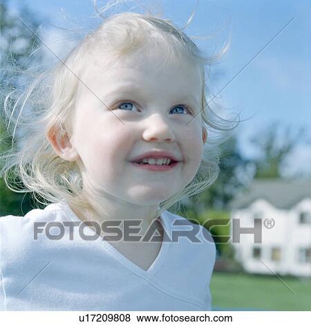 Stock Photo - Girl smiling in backyard. Fotosearch