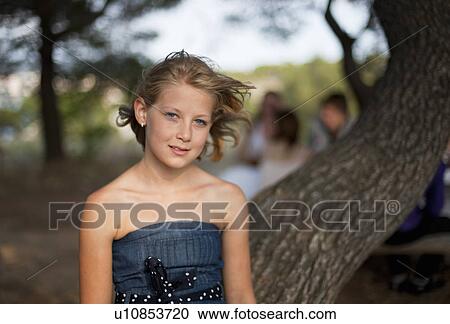 Girl standing by tree outdoors View Large Photo Image Stock Image - Girl standing by tree outdoors. Fotosearch
