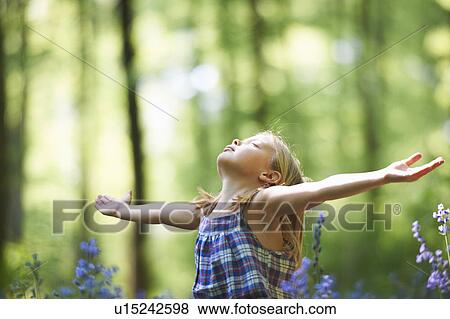 Girl standing in field of flowers View Large Photo Image Stock Photo - Girl standing in field of flowers. Fotosearch
