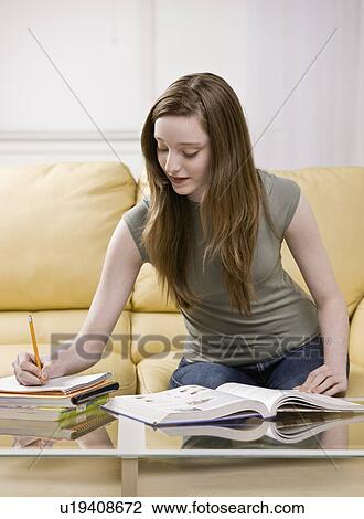 Girl studying in living room View Large Photo Image Stock Image - Girl studying in living room. Fotosearch