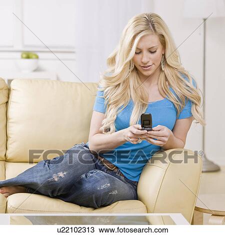 Girl using cell phone on couch View Large Photo Image Stock Image - Girl using cell phone on couch. Fotosearch