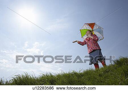 Girl using umbrella on sunny day View Large Photo Image Stock Photograph - Girl using umbrella on sunny day. Fotosearch