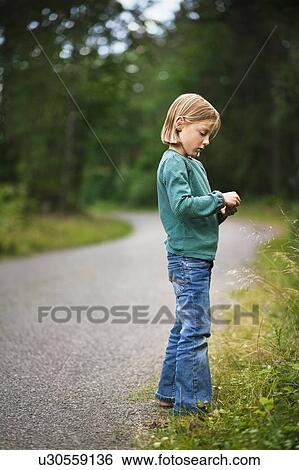 Girl walking along rural road View Large Photo Image Stock Photograph - Girl walking along rural road. Fotosearch
