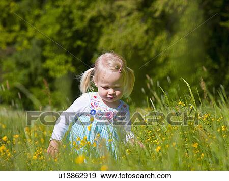 Stock Photo - Girl walking in field of flowers. Fotosearch