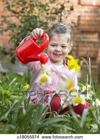 Picture - Girl watering flowers in backyard. Fotosearch