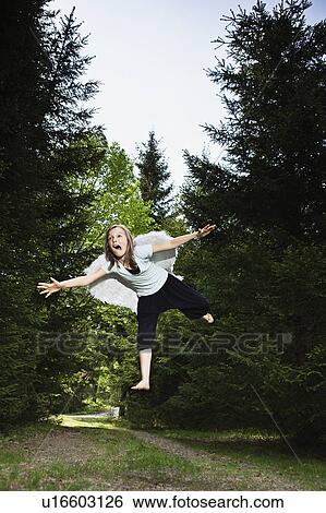 Girl wearing wings and jumping in forest View Large Photo Image Stock Photograph - Girl wearing wings and jumping in forest. Fotosearch
