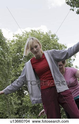 Girls balancing on walkway in park View Large Photo Image Picture - Girls balancing on walkway in park. Fotosearch