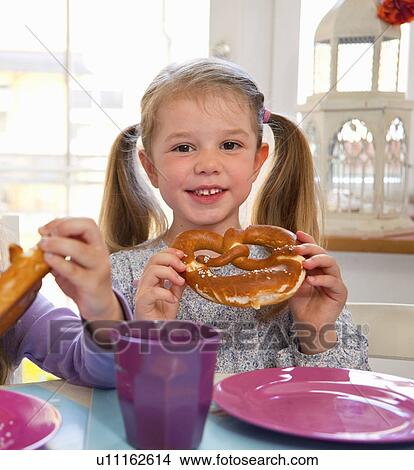 Girls eating pretzels at table View Large Photo Image Picture - Girls eating pretzels at table. Fotosearch