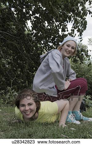 Stock Image - Girls exercising together in park. Fotosearch