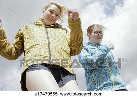 Girls in parkas walking against blue sky View Large Photo Image Stock Photography - Girls in parkas walking against blue sky. Fotosearch