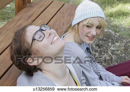 Girls leaning on park bench View Large Photo Image Stock Photo - Girls leaning on park bench. Fotosearch