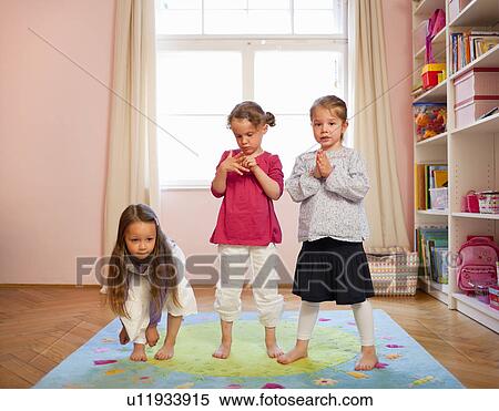 Stock Photography - Girls playing together on rug. Fotosearch